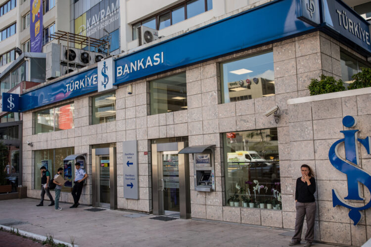 People are seen outside Turkey's IS Bank in the financial district of the city on Tuesday, August 14, 2018 in Istanbul, Turkey. Turkey's currency has fallen to record lows over the last few days as a result of rapid inflation and economic problems in the country.